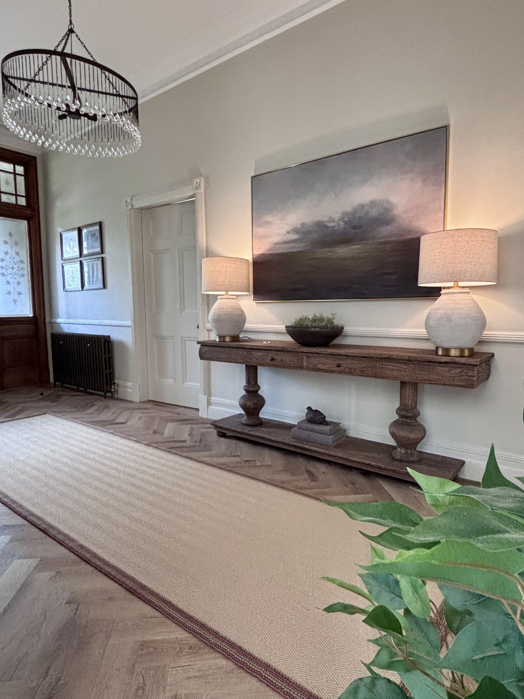 Interior with a console table, artwork and a view through the doorway