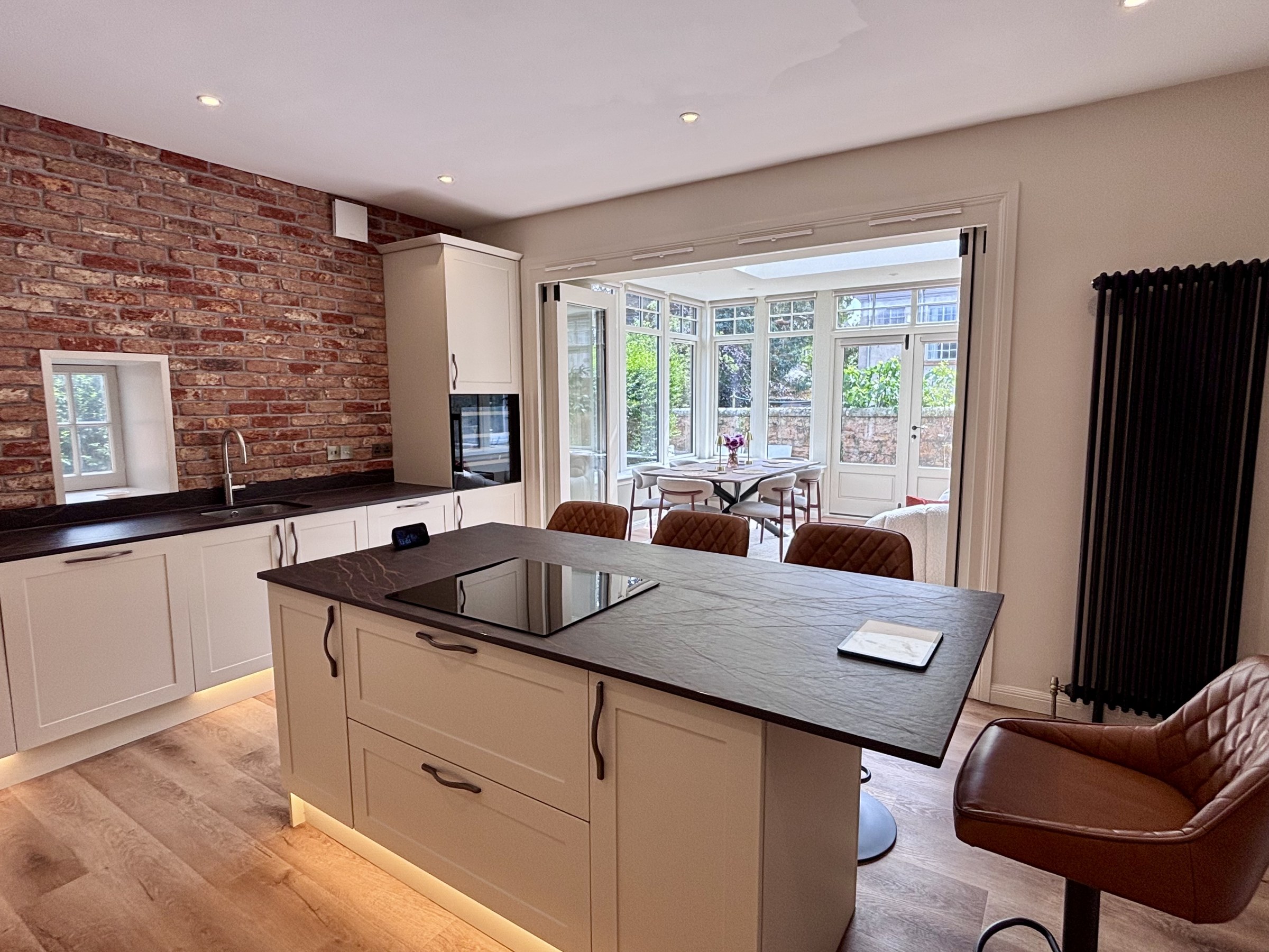 Kitchen island and cabinetry beside a large window