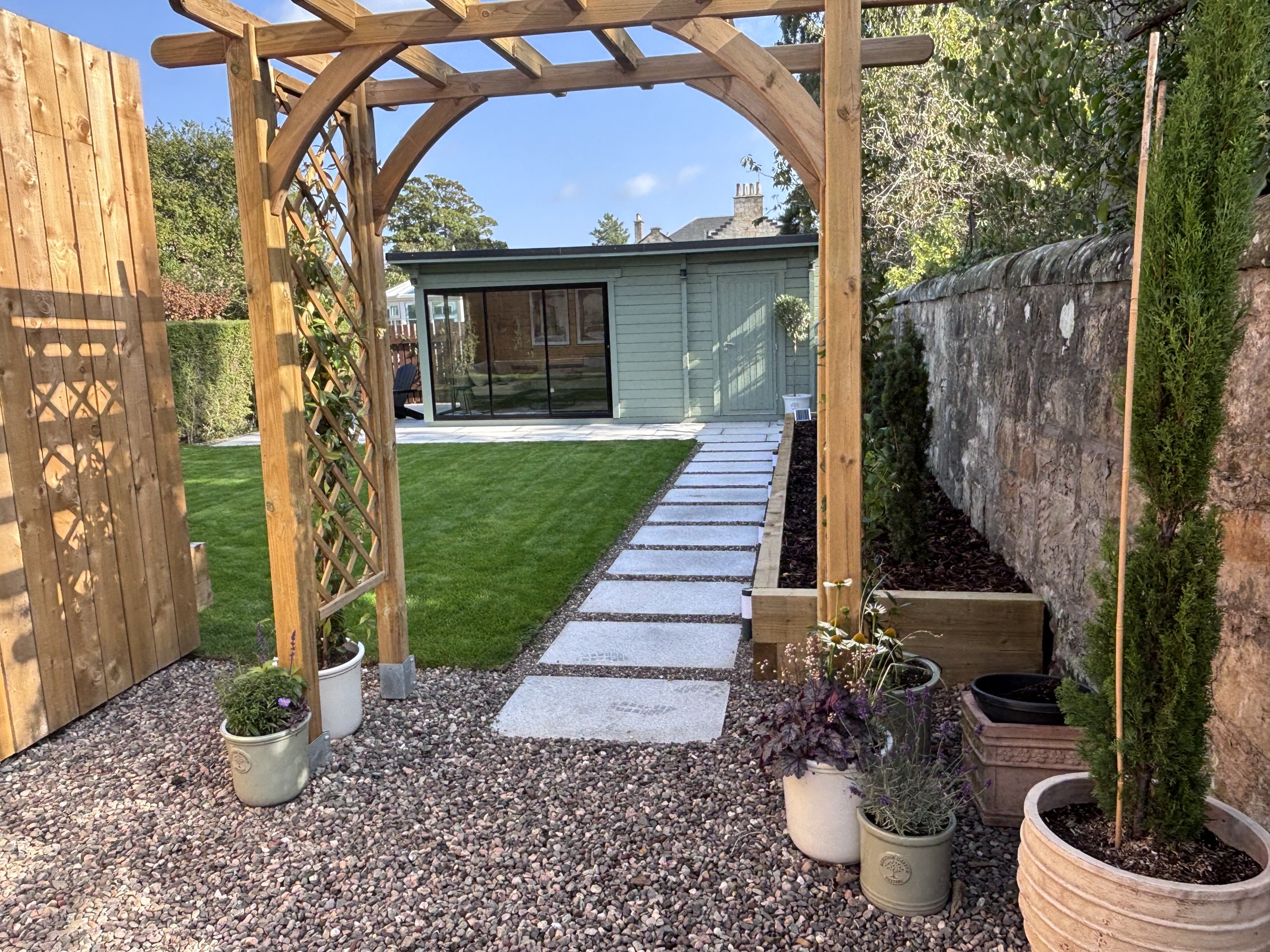 Timber garden arch framing the lawn and garden room