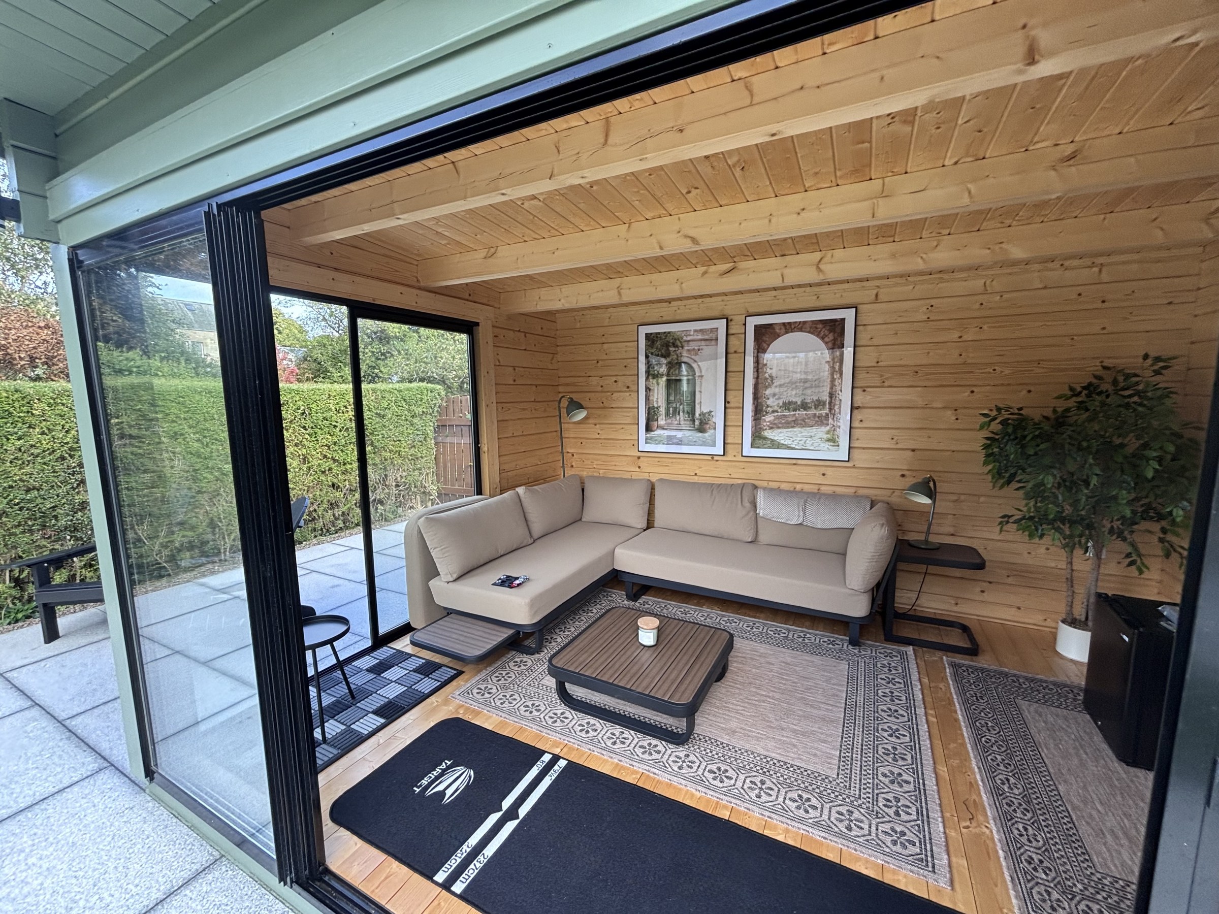 Timber-lined garden room with seating and sliding glass doors