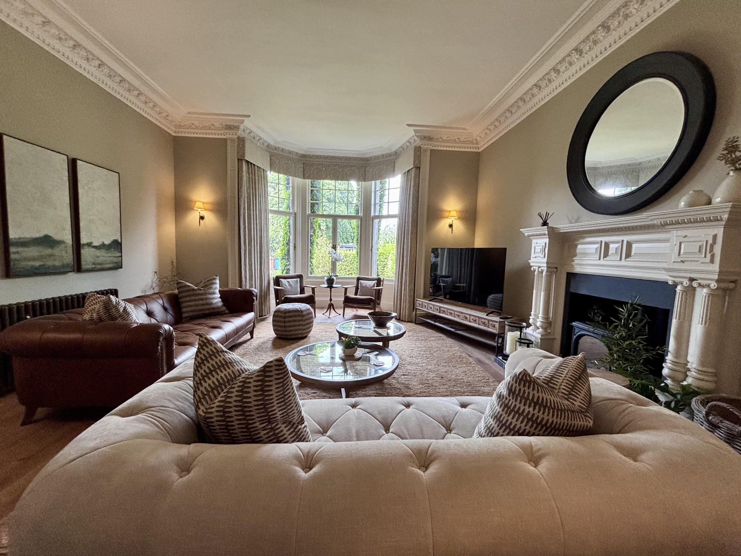 Light-filled living room with a bay window, sofas and fireplace