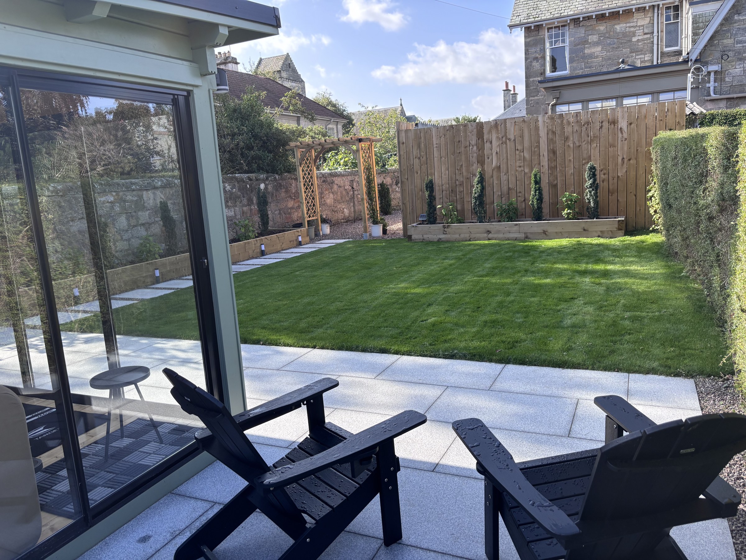 Garden lawn and patio seating beside the conservatory