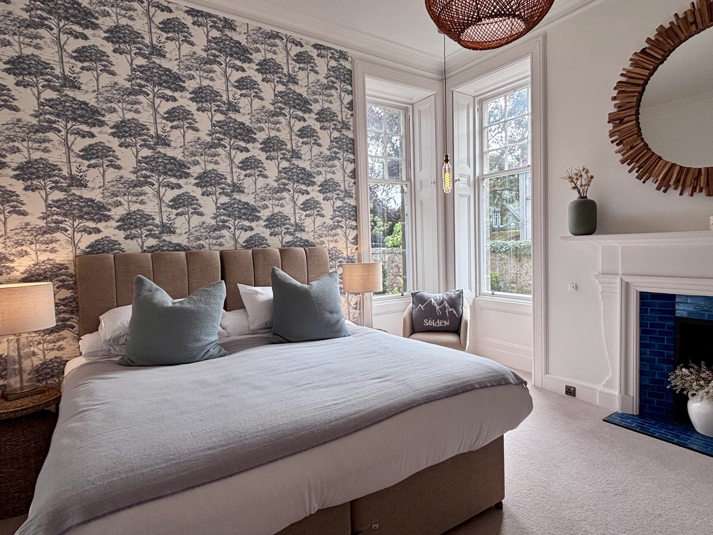 Bedroom with botanical wallpaper, a double bed and fireplace